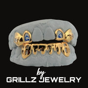 Gold and gray grill with blue accents on a black background, branded by Grillz Jewelry.