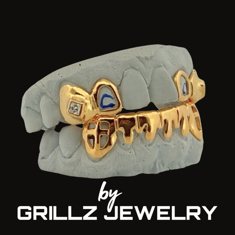 Gold grillz on a gray skull with 'GRILLZ JEWELRY' branding.