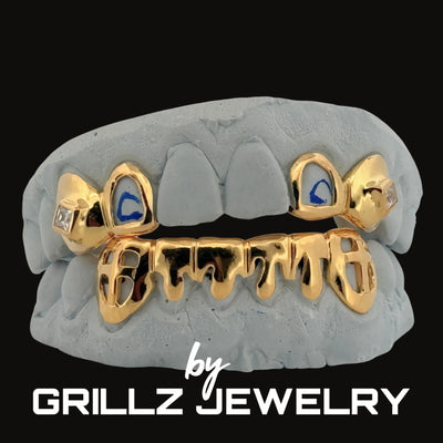 Gold grillz with blue accents on a gray background, branded by Grillz Jewelry.