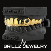 Grillz jewelry set on a black stand with 'Grillz Jewelry' branding.