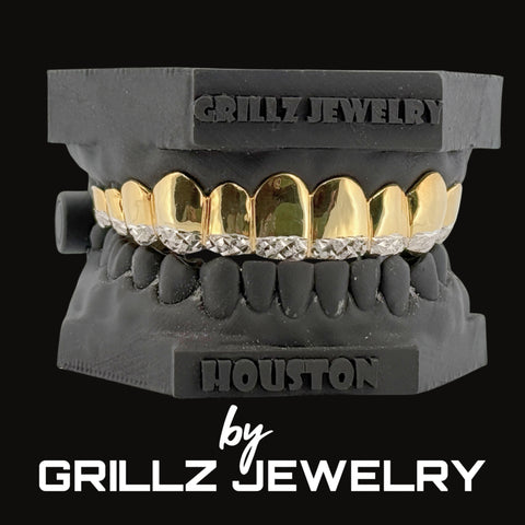 Gold and silver grillz on a black dentures model with 'Grillz Jewelry' branding.