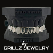 Silver grill with decorative elements on a clear background, branded 'Grillz Jewelry'.