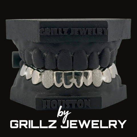 Silver grill with decorative elements on a clear background, branded 'Grillz Jewelry'.