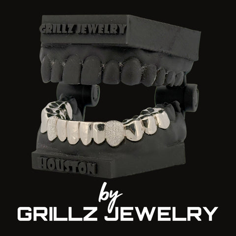 Silver grill on a black jaw model with 'Grillz Jewelry' branding.