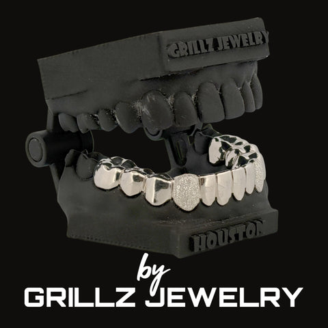 Silver grillz on a black stand with 'Grillz Jewelry' branding.