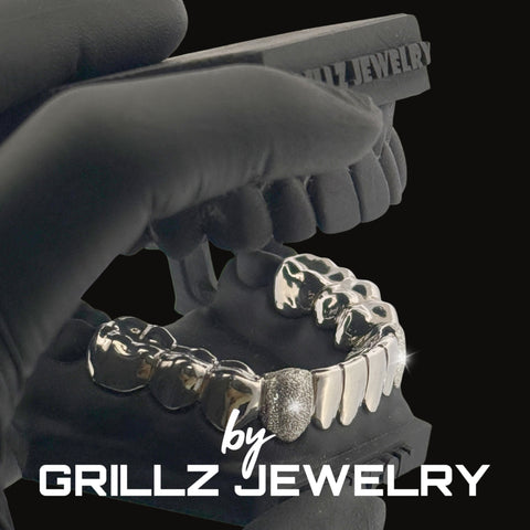 Silver grillz jewelry set held by a gloved hand with 'Grillz Jewelry' branding.