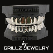 Silver grillz on a black stand with 'Grillz Jewelry' branding.