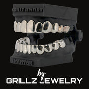 Silver grillz on a black stand with 'Grillz Jewelry' branding.