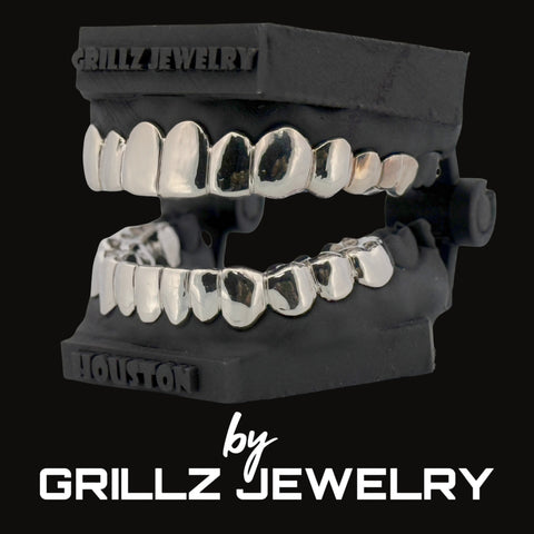 Silver grillz on a black stand with 'Grillz Jewelry' branding.