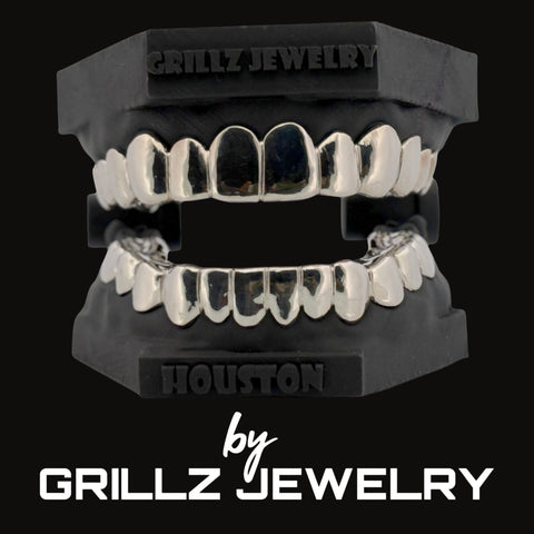 Silver grillz jewelry set on a black stand with 'Grillz Jewelry' branding.