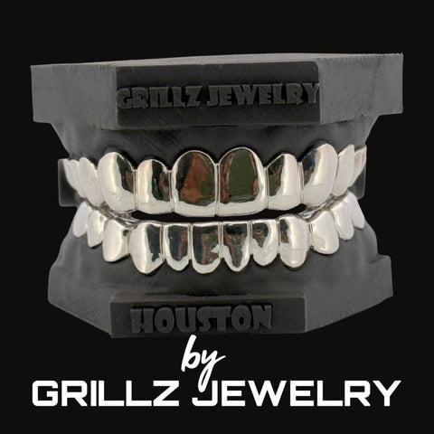 Silver grillz on a black stand with 'Grillz Jewelry' branding.