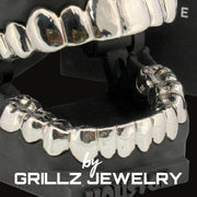 Silver grillz jewelry set on a black stand with 'Grillz Jewelry' branding.