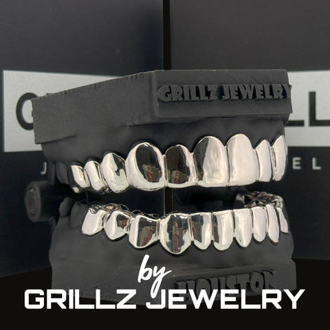 Silver grillz jewelry set on a black stand with 'Grillz Jewelry' branding.