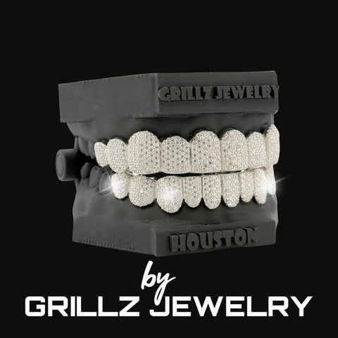 Diamond-studded grill on a black stand with 'Grillz Jewelry' branding.
