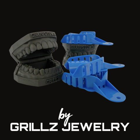 Gray and blue plastic grillz on a black background with 'Grillz Jewelry' branding.