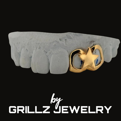 Grillz with gold star and moon design on a gray stone background, branded by Grillz Jewelry.