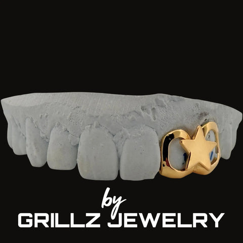 Gray tooth grill with gold accessory on a black background, branded as Grillz Jewelry.