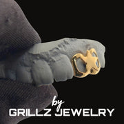 Gold star grill on a person's teeth with 'GRILLZ JEWELRY' branding.