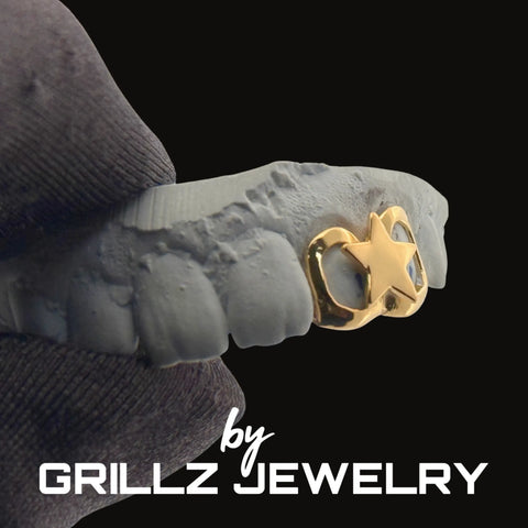 Gold star grill on a person's teeth with 'GRILLZ JEWELRY' branding.