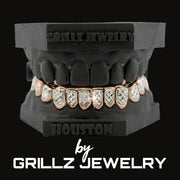 Grillz jewelry set with rose gold and clear stones on a black background, branded as Grillz Jewelry.