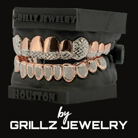 Set of rose gold and silver grillz on a black stand with 'Grillz Jewelry' branding.