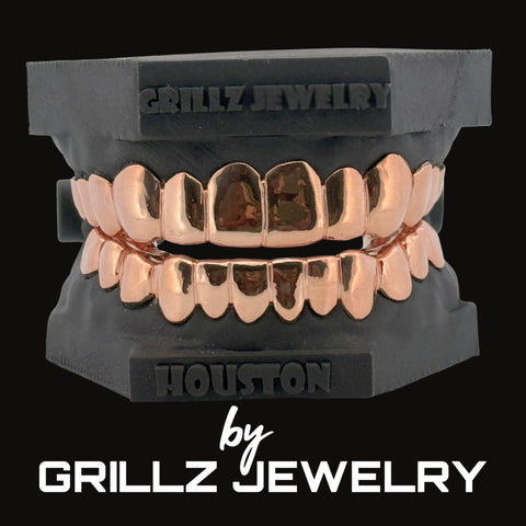 Rose gold grillz on a black stand with 'Grillz Jewelry' branding.