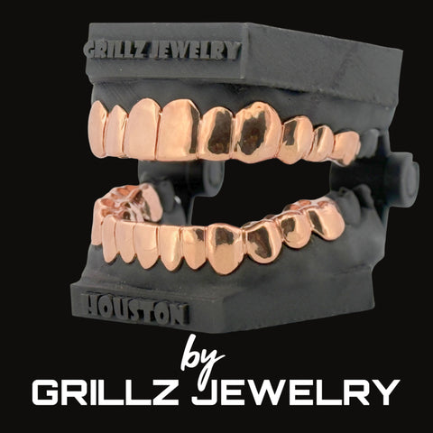 Rose gold grillz on black mannequin mouth with 'Grillz Jewelry' branding.