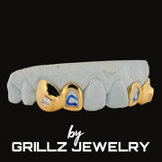 Gray and gold grillz with blue accents on a black background, branded as Grillz Jewelry.