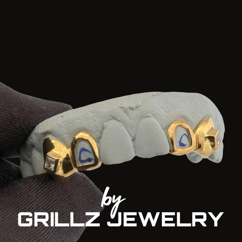Grillz jewelry with gold and blue accents on a black background, featuring the brand 'Grillz Jewelry'.