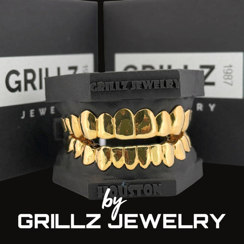 Gold grillz on a black stand with 'Grillz Jewelry' branding in the background.