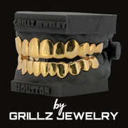 Gold grillz on a black stand with 'Grillz Jewelry' branding.