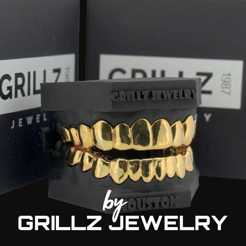 Gold grillz on a black stand with 'Grillz Jewelry' branding in the background.