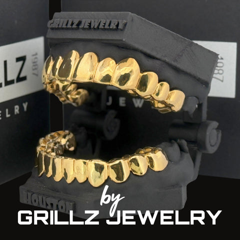 Gold grillz on a black stand with 'Grillz Jewelry' branding.