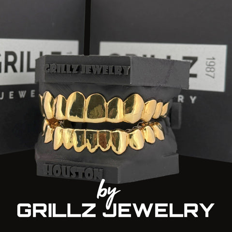 Gold grillz on a black stand with 'Grillz Jewelry' branding in the background.